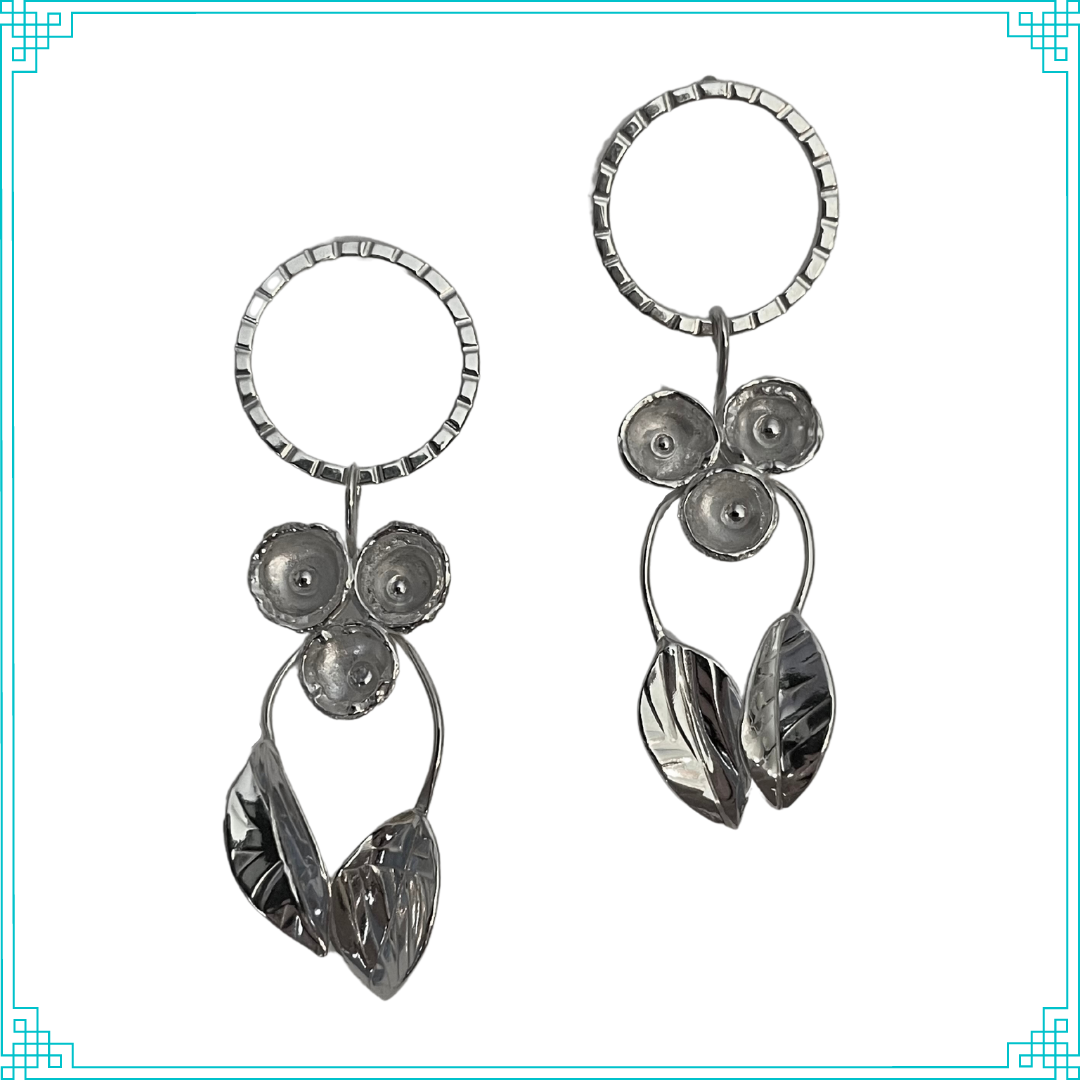 Sleeping Fox handmade sterling silver earrings with three grouped flowers and two leaves on stems hanging from the posted top circle.