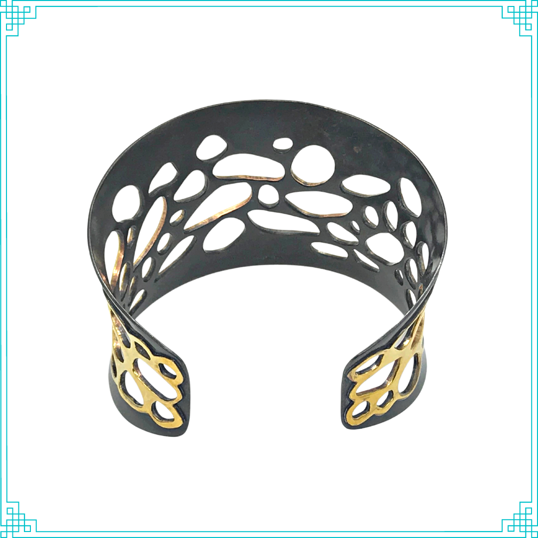 Sleeping Fox quality handmade jewelry presents Pathways Cuff Bracelet. This bracelet has a wonderful comfort fit due to it's anticlastic shape. Anticlastic means the material has a curve going in two different directions. The base material is copper and the top element is brass. The whole piece has been given a patina of black and the patina has been polished off the brass.
