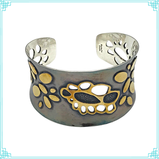 Sleeping Fox quality handmade silver jewelry presents Golden Doily Cuff Bracelet. This bracelet has a wonderful comfort fit due to it's anticlastic shape. Anticlastic means the material has a curve going in two different directions. The base material is silver and the top elements are brass. The outer face of the piece has been given a patina of black and the patina has been polished off the brass.