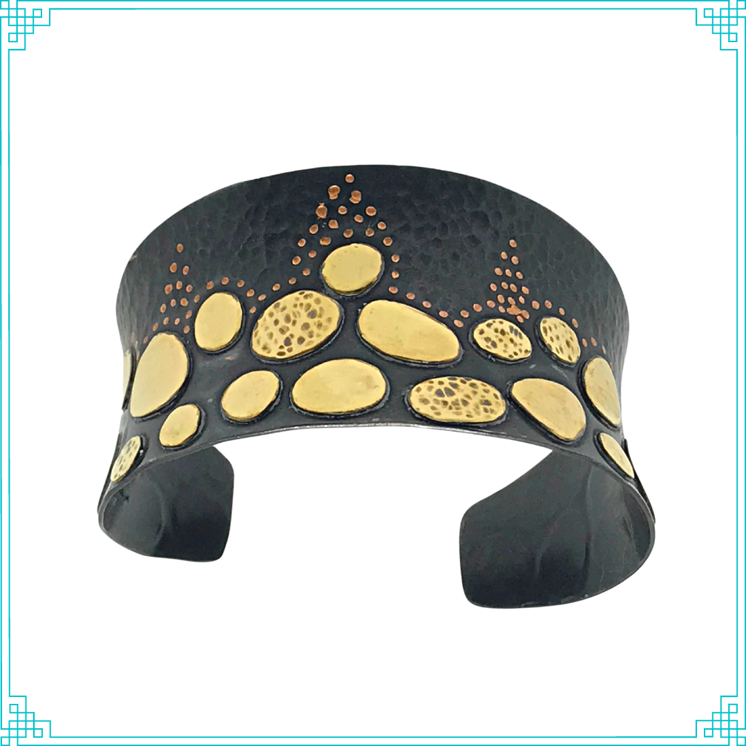 Sleeping Fox quality handmade jewelry presents Splendid Diadem Cuff Bracelet. This bracelet has a wonderful comfort fit due to it's anticlastic shape. Anticlastic means the material has a curve going in two different directions. The base material is copper and the top elements are brass. The whole piece has been given a patina of black and the patina has been polished off the brass. The dot design is done with a ball bur and some of the brass pieces have a hammered texture.