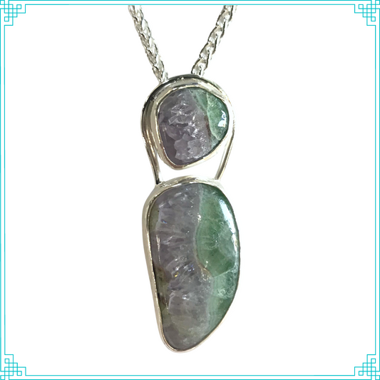 Sleeping Fox quality handmade sterling silver jewelry presents Divided Pendant. The design follows through with what nature started, adding to the illusion of division in the stones. Nature pairing Florite and Amethyst together is a rare occurrence. This sterling silver pendant hangs from a 2.5mm sterling wheat chain.