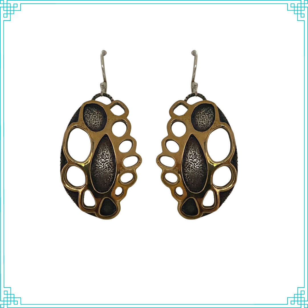 Sleeping Fox handmade silver jewelry presents Golden Doily Earrings. This two layer design of silver and brass gives a unique doily look because of the oval cut-outs around the filled in chambers in the center. Earrings hang from a handmade sterling silver ear wire.