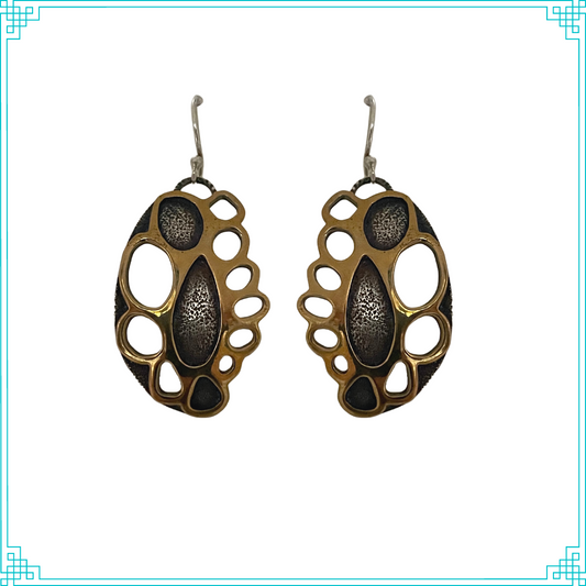Sleeping Fox handmade silver jewelry presents Golden Doily Earrings. This two layer design of silver and brass gives a unique doily look because of the oval cut-outs around the filled in chambers in the center. Earrings hang from a handmade sterling silver ear wire.