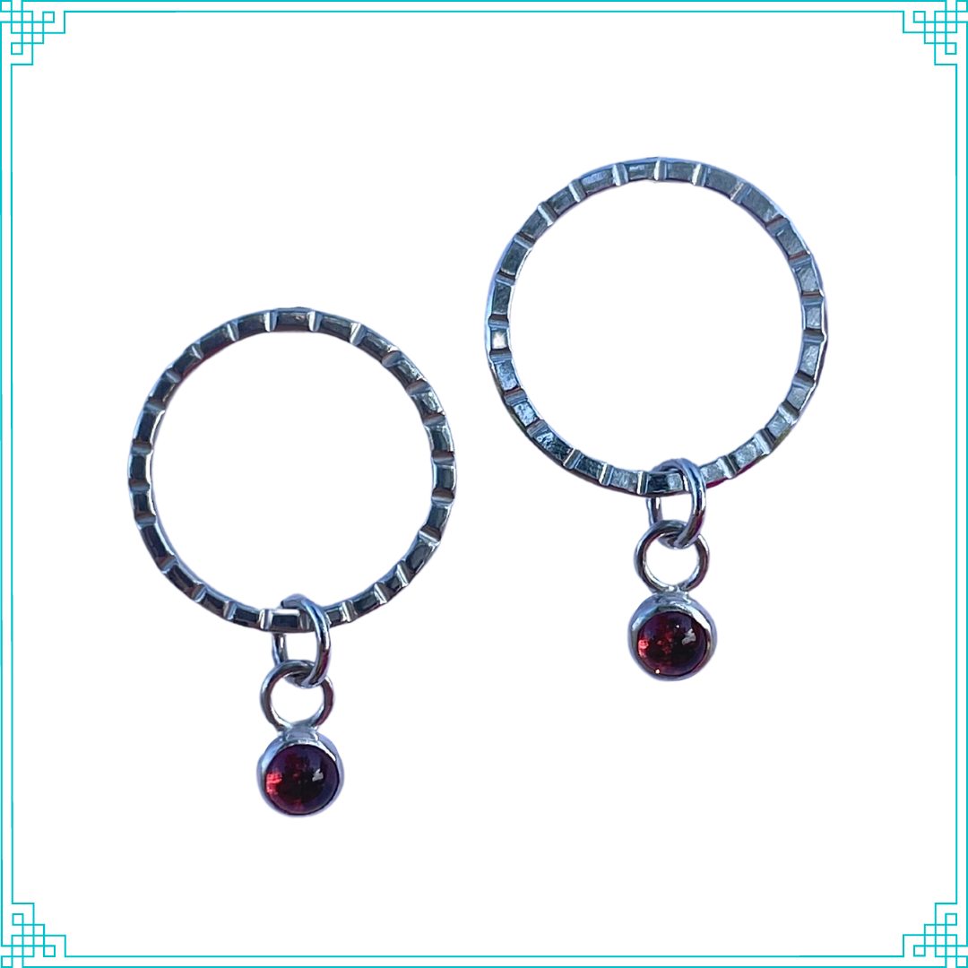 Sleeping Fox handmade sterling silver earrings feature quality 4mm garnet set in a bezel hangs from line textured circle with post.