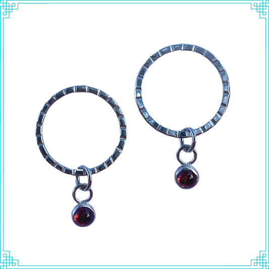 Sleeping Fox handmade sterling silver earrings feature quality 4mm garnet set in a bezel hangs from line textured circle with post.