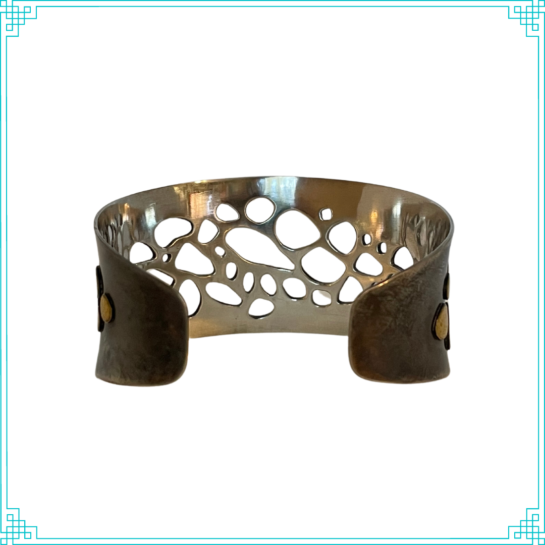 Sleeping Fox quality handmade silver jewelry presents Less is More Cuff Bracelet. This bracelet has a wonderful comfort fit due to it's anticlastic shape (curve going in two different directions). The base material is silver and the top elements are brass.  The whole piece has been given a patina of black and the patina has been polished off the brass.  The dot design is done with a ball bur and gives a lacy effect.