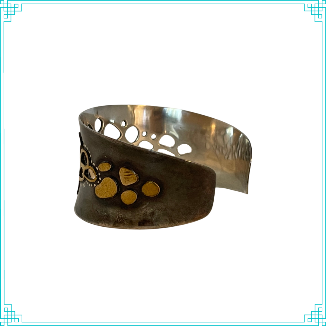 Sleeping Fox quality handmade silver jewelry presents Less is More Cuff Bracelet. This bracelet has a wonderful comfort fit due to it's anticlastic shape (curve going in two different directions). The base material is silver and the top elements are brass. The whole piece has been given a patina of black and the patina has been polished off the brass. The dot design is done with a ball bur and gives a lacy effect.