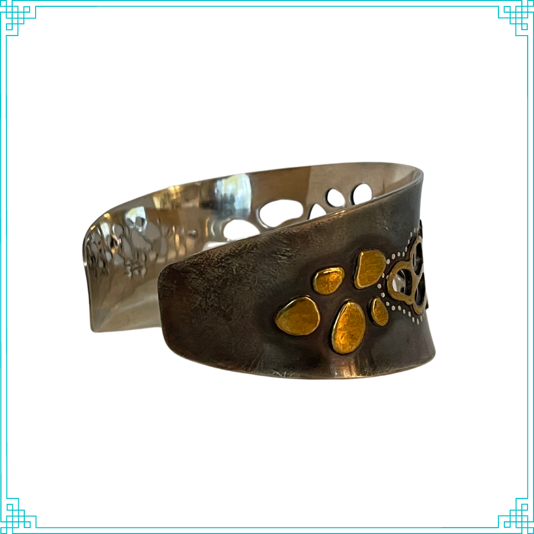 Sleeping Fox quality handmade silver jewelry presents Less is More Cuff Bracelet. This bracelet has a wonderful comfort fit due to it's anticlastic shape (curve going in two different directions). The base material is silver and the top elements are brass.  The whole piece has been given a patina of black and the patina has been polished off the brass.  The dot design is done with a ball bur and gives a lacy effect.