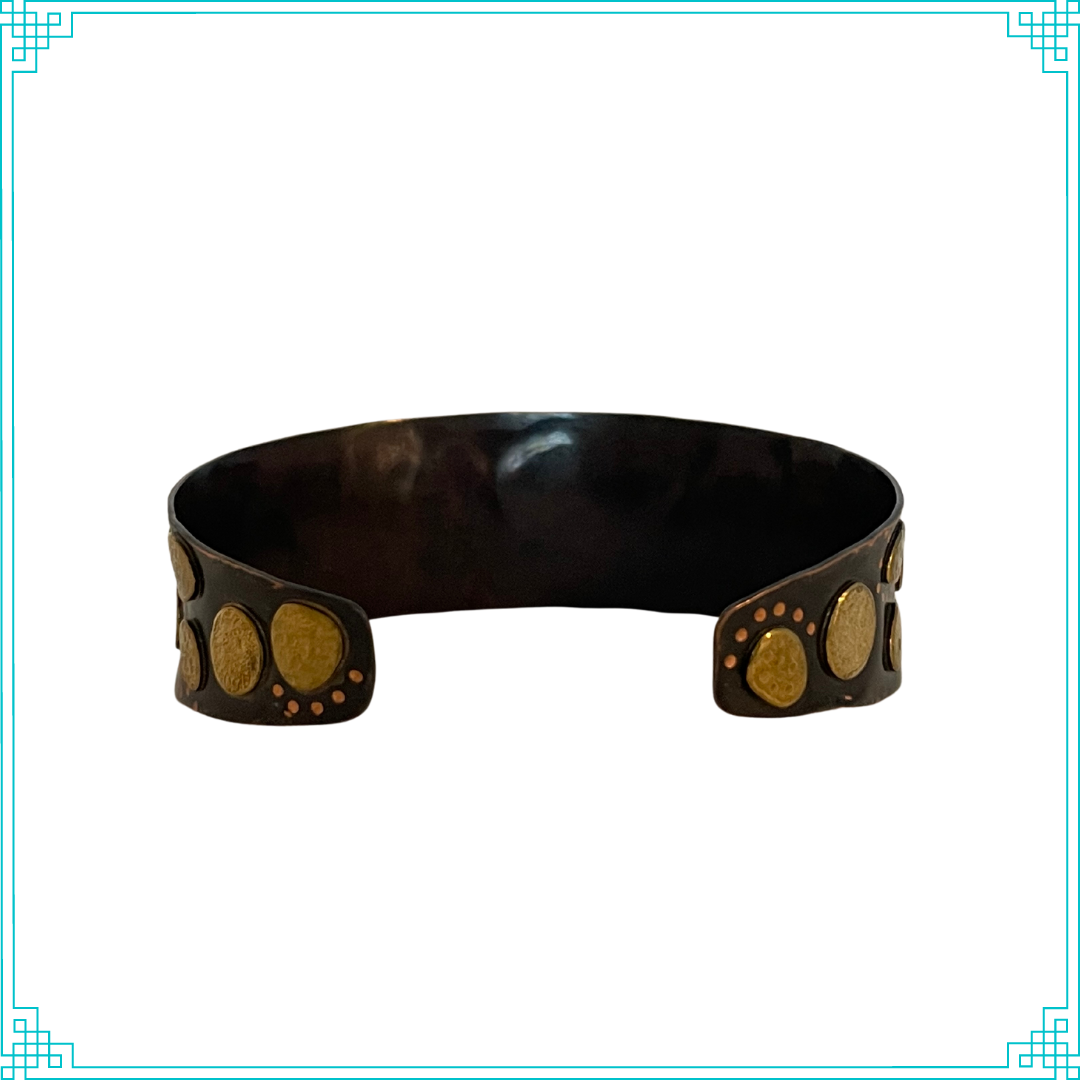 Sleeping Fox quality handmade jewelry presents Nuggets Cuff Bracelet. This bracelet has a wonderful comfort fit due to it's anticlastic shape. Anticlastic means the material has a curve going in two different directions. The base material is copper and the top elements are brass. The whole piece has been given a patina of black and the patina has been polished off the brass. The dot design is done with a ball bur.