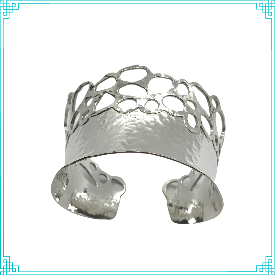 Sleeping Fox quality handmade silver jewelry presents Planished Beauty Cuff Bracelet. This crown of silver adorns your wrist with comfort due to its anticlastic shape. Anticlastic means the material has a curve going in two different directions. This is a special piece you may wear on your next date night. This design features hammer texture and double layers of silver where the cut outs occur.