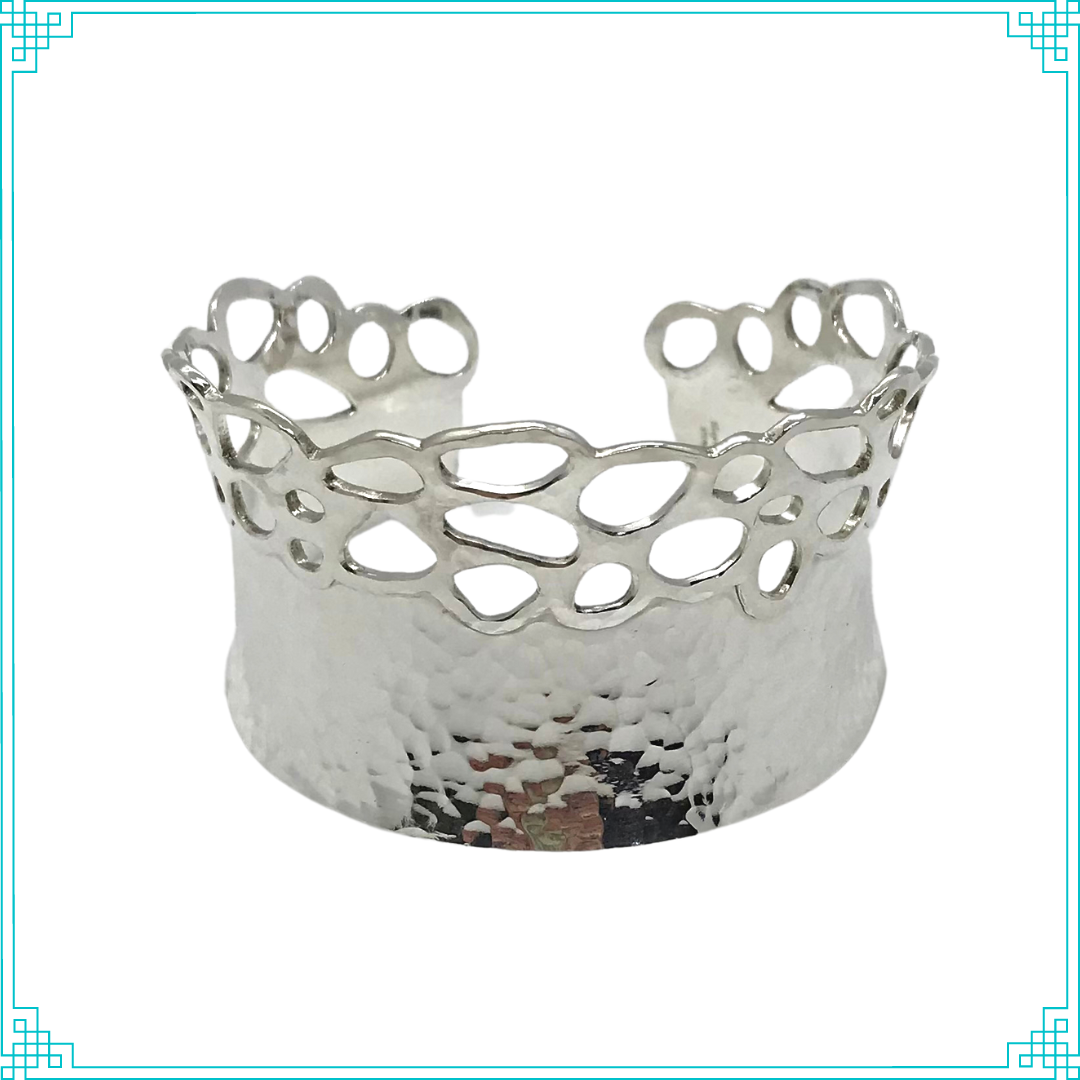 Sleeping Fox quality handmade silver jewelry presents Planished Beauty Cuff Bracelet. This crown of silver adorns your wrist with comfort due to its anticlastic shape. Anticlastic means the material has a curve going in two different directions. This is a special piece you may wear on your next date night. This design features hammer texture and double layers of silver where the cut outs occur.