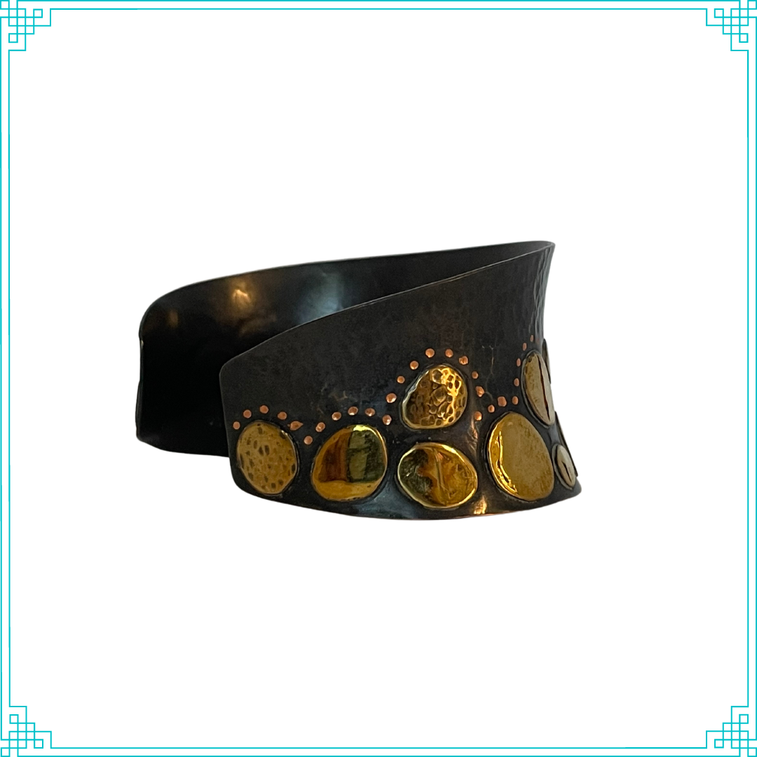 Sleeping Fox quality handmade jewelry presents Splendid Diadem Cuff Bracelet. This bracelet has a wonderful comfort fit due to it's anticlastic shape. Anticlastic means the material has a curve going in two different directions. The base material is copper and the top elements are brass. The whole piece has been given a patina of black and the patina has been polished off the brass. The dot design is done with a ball bur and some of the brass pieces have a hammered texture.