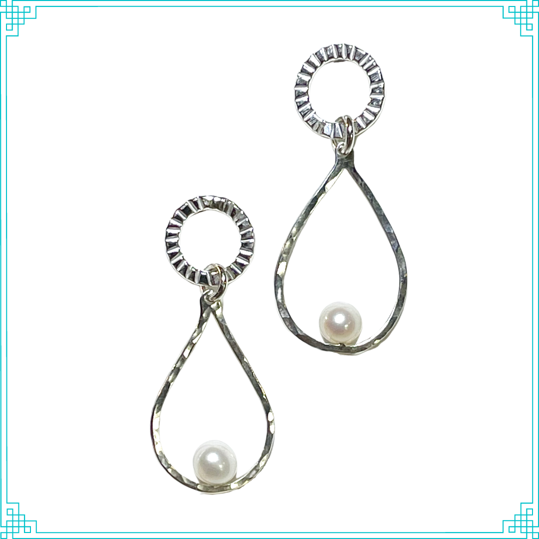 Sleeping Fox handmade sterling silver post earrings feature hammer-textured tear drops with white pearls sitting on soldered posts.