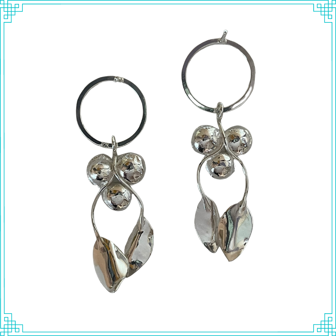 Sleeping Fox handmade sterling silver earrings with three grouped flowers and two leaves on stems hanging from  the posted top circle.