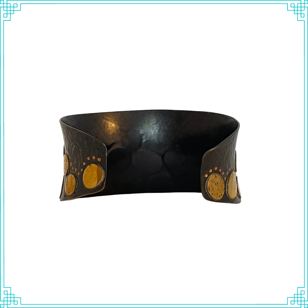 Sleeping Fox quality handmade jewelry presents Splendid Diadem Cuff Bracelet. This bracelet has a wonderful comfort fit due to it's anticlastic shape. Anticlastic means the material has a curve going in two different directions. The base material is copper and the top elements are brass. The whole piece has been given a patina of black and the patina has been polished off the brass. The dot design is done with a ball bur and some of the brass pieces have a hammered texture.