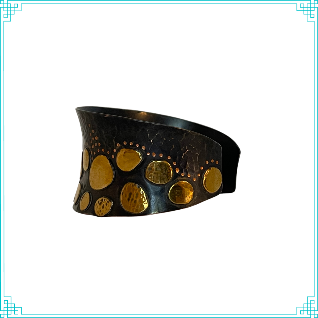 Sleeping Fox quality handmade jewelry presents Splendid Diadem Cuff Bracelet. This bracelet has a wonderful comfort fit due to it's anticlastic shape. Anticlastic means the material has a curve going in two different directions. The base material is copper and the top elements are brass. The whole piece has been given a patina of black and the patina has been polished off the brass. The dot design is done with a ball bur and some of the brass pieces have a hammered texture.